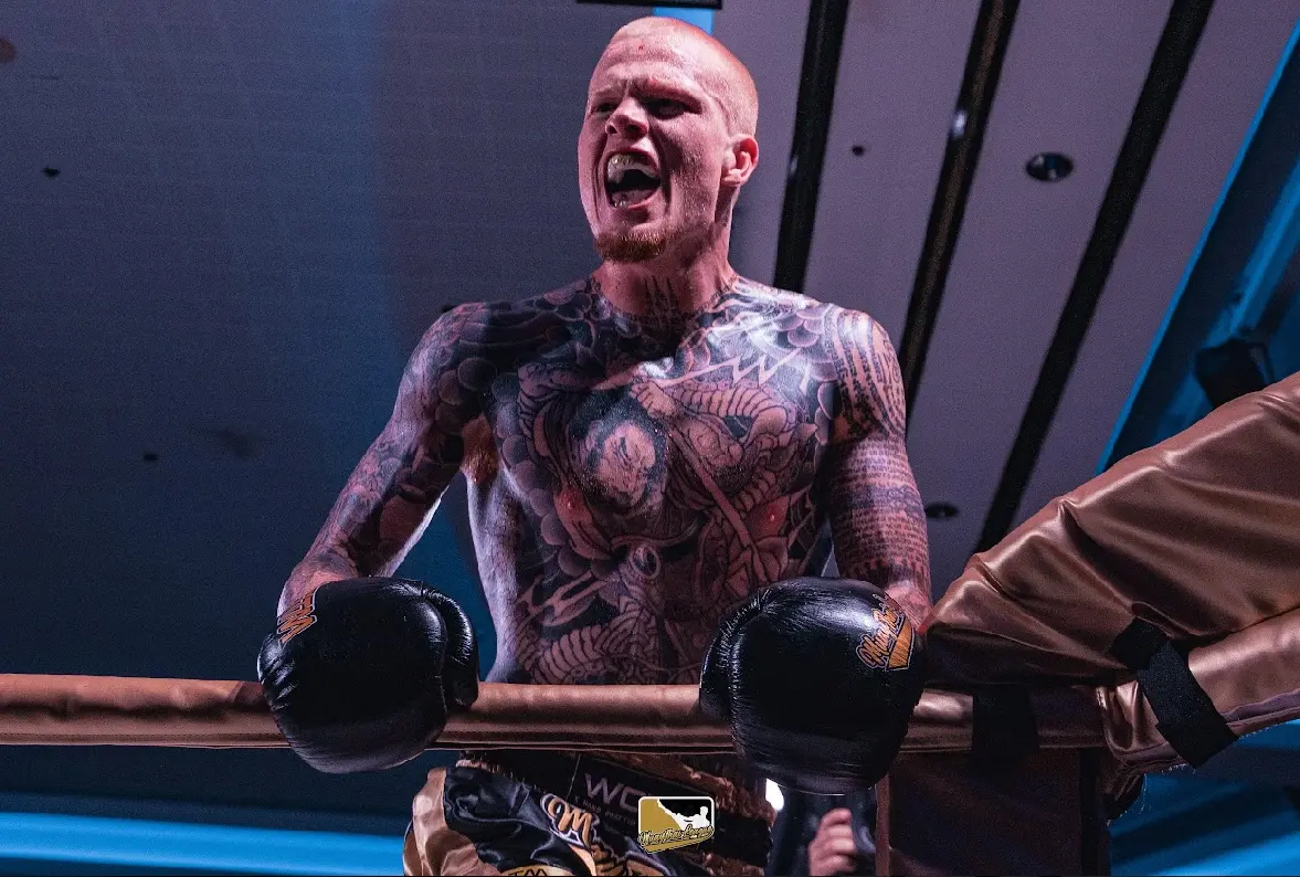 Brandon Spain in the ring during a Muay Thai bout, gloves raised